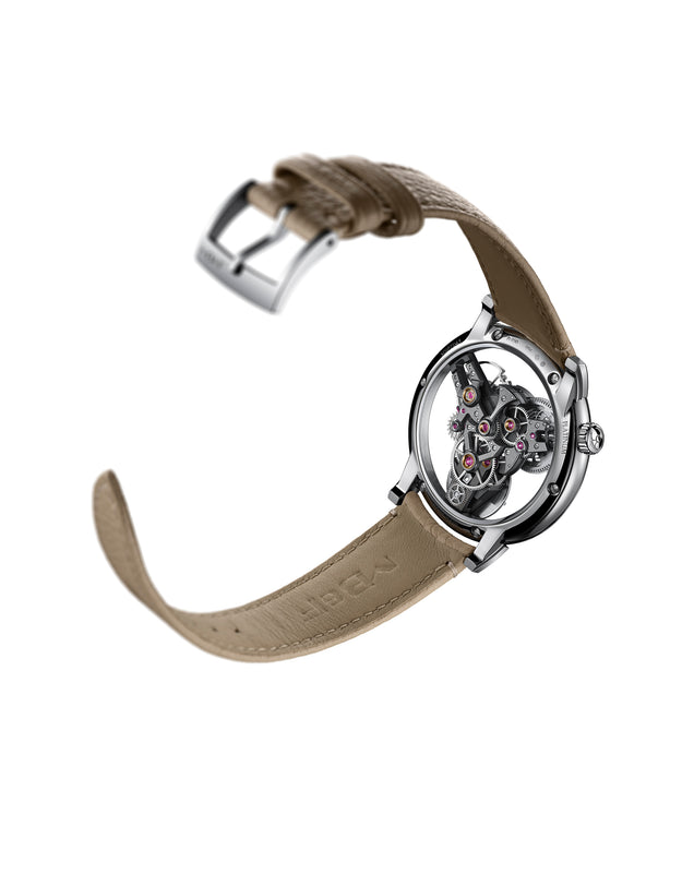 The MB&F SP One Platinum is a luxury wristwatch featuring a tan leather strap and an exposed mechanical movement, showcased against a white background.