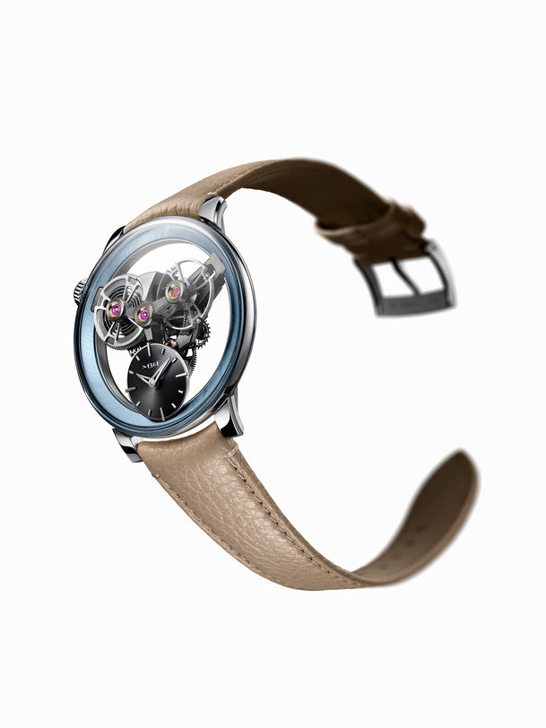 The MB&F SP One Platinum is a luxury watch featuring exposed gears, a silver case, and a beige leather strap, displayed on a white background.