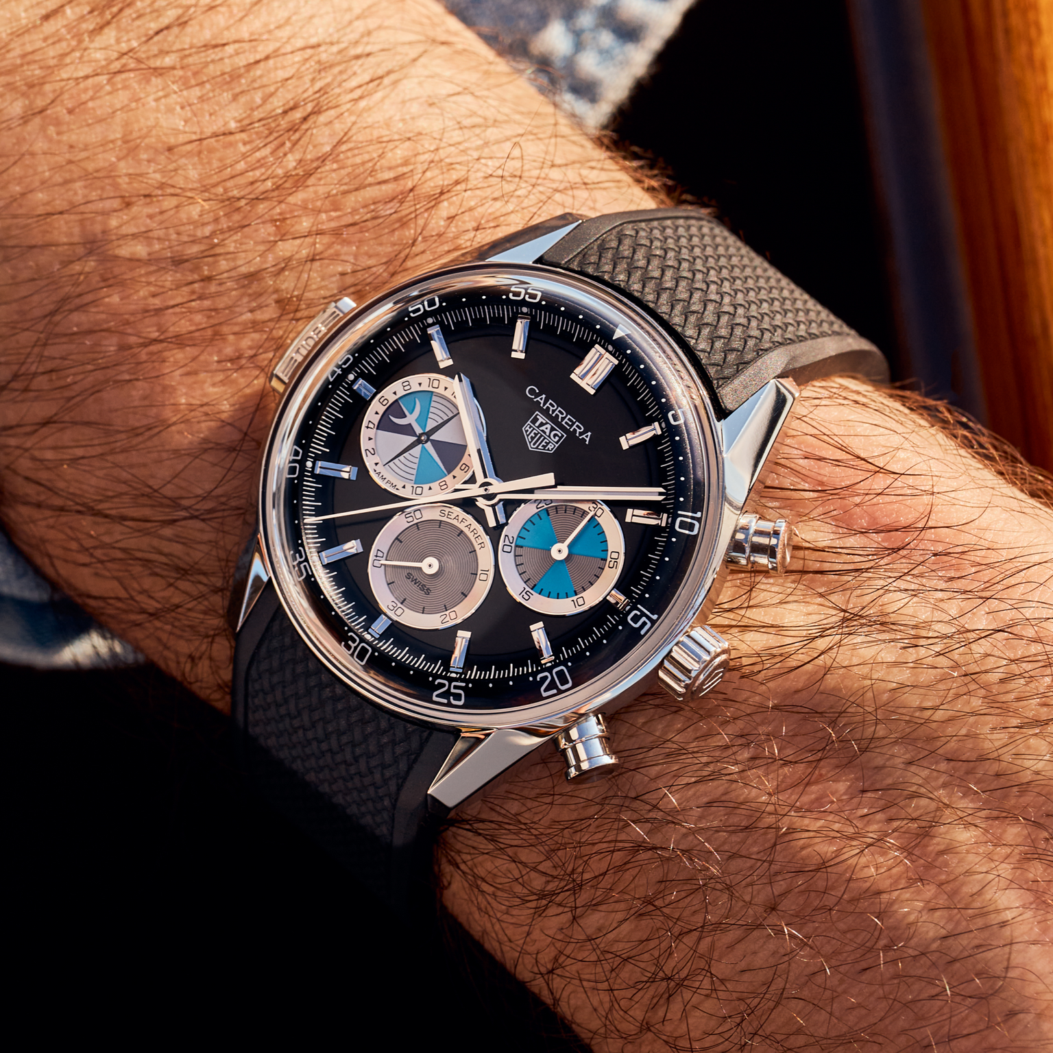 A TAG Heuer Carrera Chronograph Seafarer × Hodinkee watch from TAG Heuer with a black strap on a mans wrist.