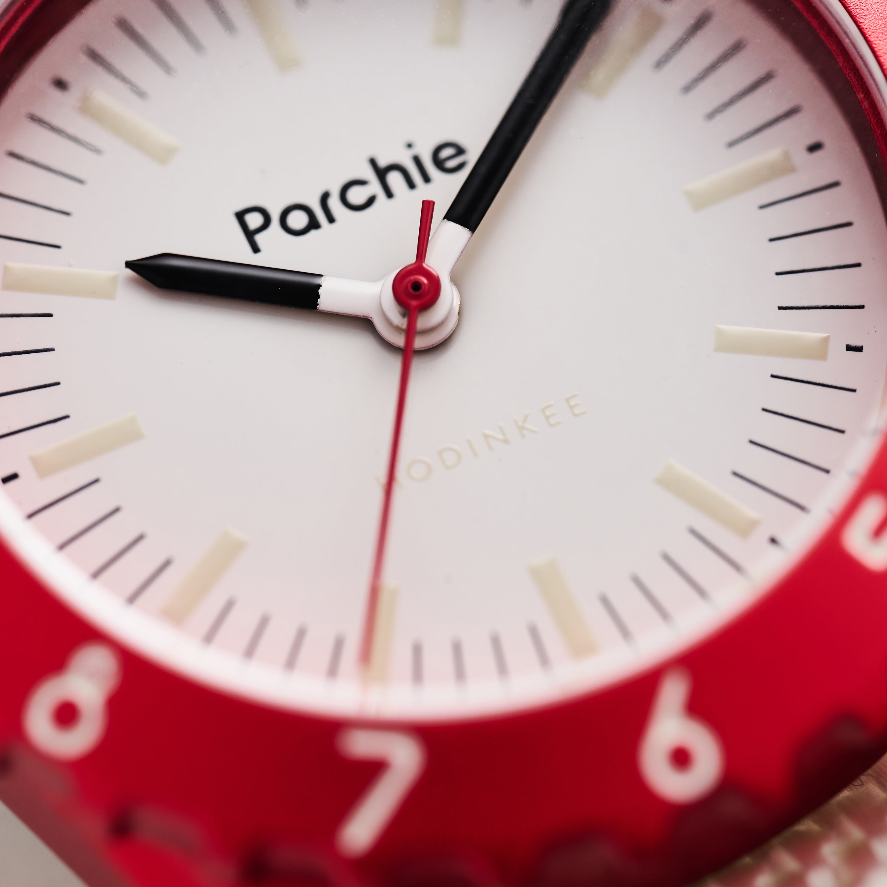 Close-up of a red Parchie Lunar-Time Limited Editions for Hodinkee 32 wristwatch displaying the time as 9:05:31.