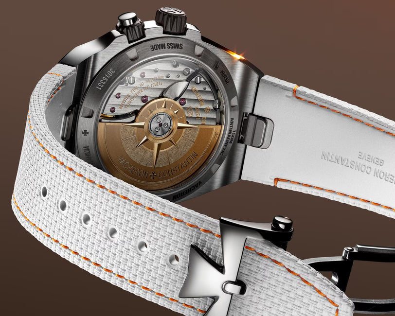 Stainless steel chronograph watch with bronze dial featuring ship's wheel design and white fabric strap with orange stitching