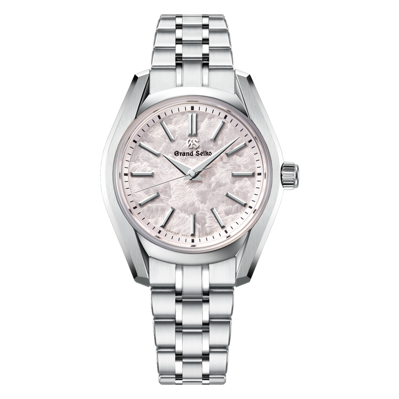 Silver-tone Grand Seiko watch with light pink dial, textured surface, hour markers, and matching metal bracelet.