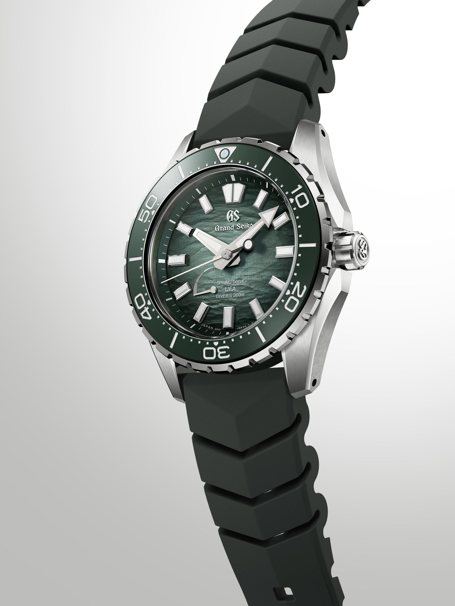 Grand Seiko diving watch with green dial, steel case, black rubber strap, and rotating bezel.