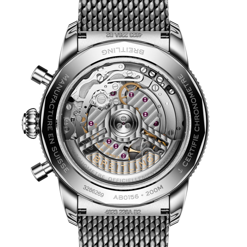 Close-up of the Breitling Superocean Heritage B01 Chronograph 42’s transparent case back, revealing its intricate mechanical movement and metal mesh strap.