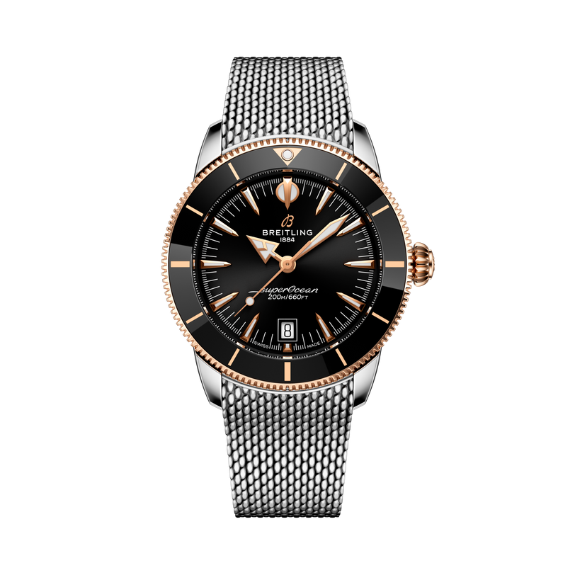 The Breitling Superocean Heritage B31 Automatic 42 features a black dial with gold accents and a silver mesh metal strap, displayed on a black background.