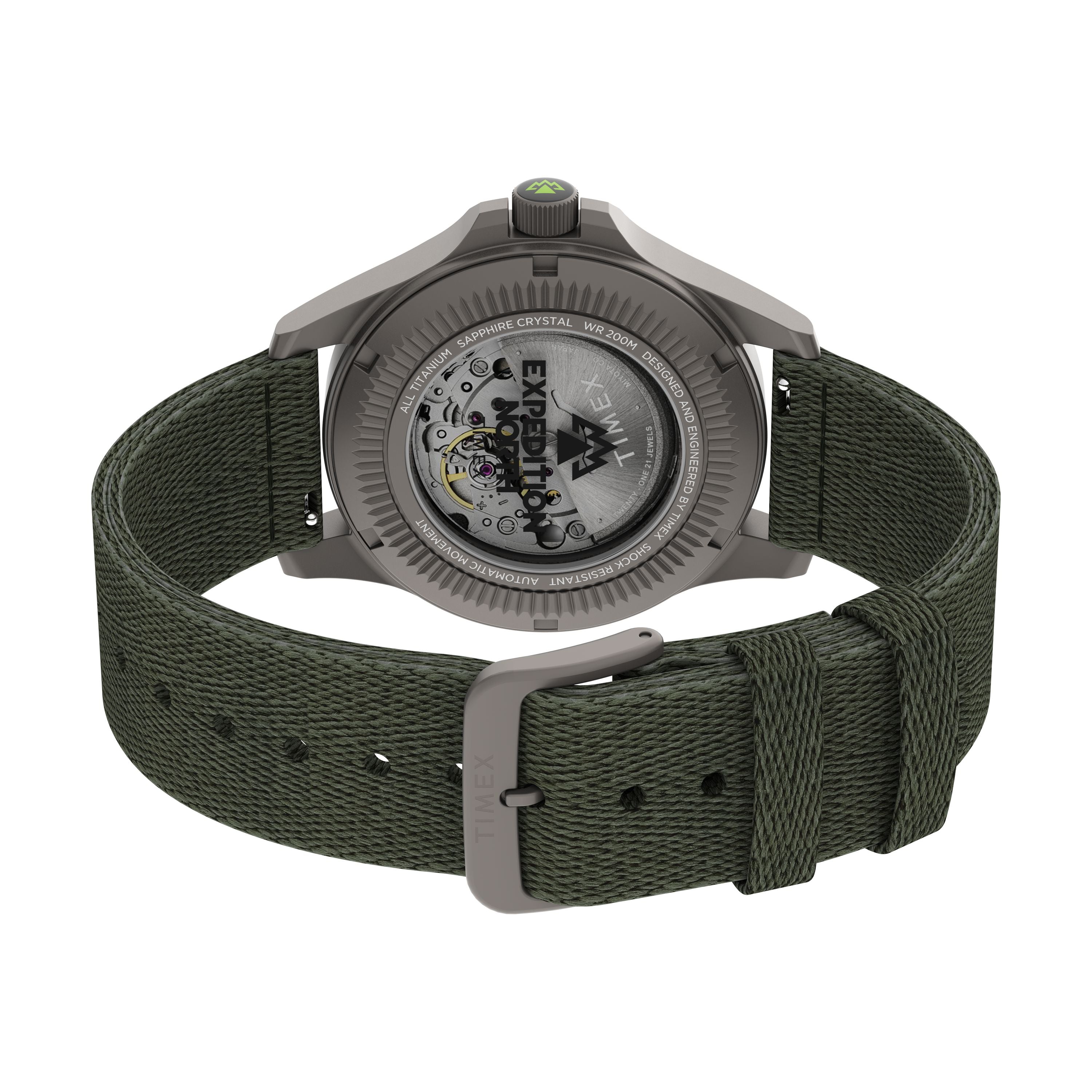 The Timex Expedition Titanium Automatic, featuring a green fabric strap and silver buckle, is shown from the back with its transparent case back revealing the Japanese automatic movement inside.