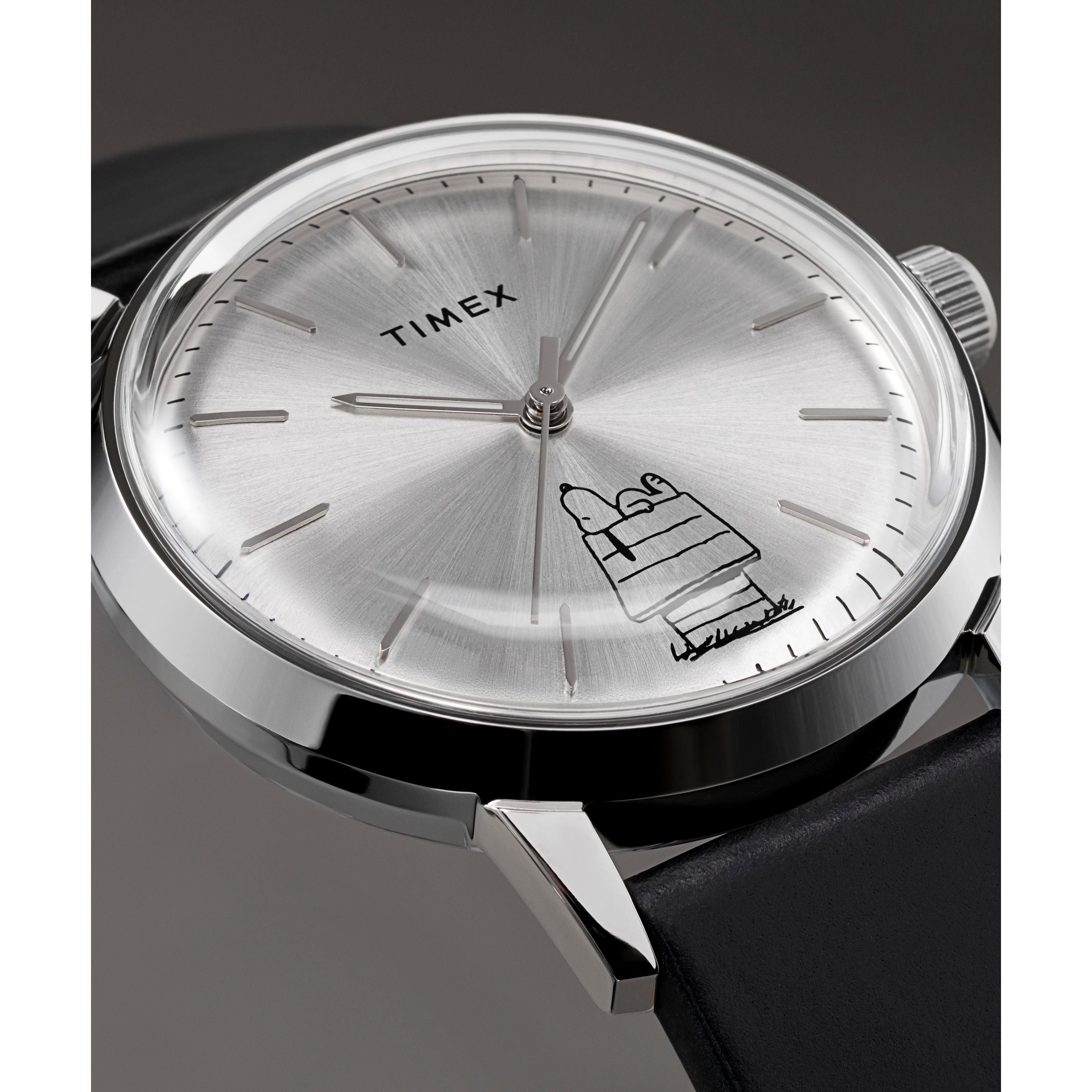 A close-up of the Timex x Peanuts® Marlin® Automatic 75th Anniversary Edition by Timex with a silver case, black leather strap, and minimalist dial featuring Snoopy lying on his doghouse for a stylish, playful touch.