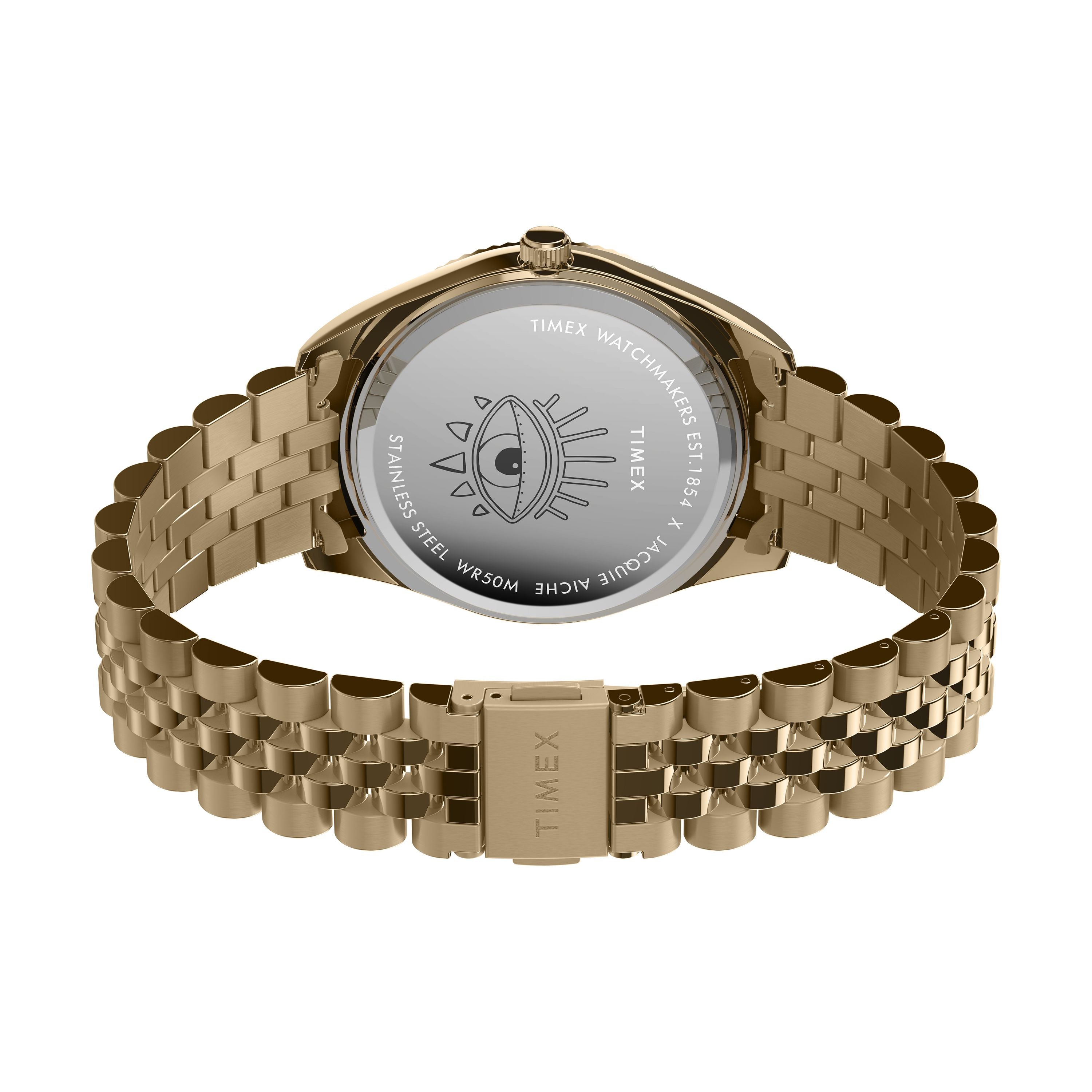 Back view of the Timex x Jacquie Aiche wristwatch reveals an engraved eye on the case back with brand details, water resistance, and materials. The gold metal bracelet is partly open, highlighting the unique artistry of this Timex timepiece.