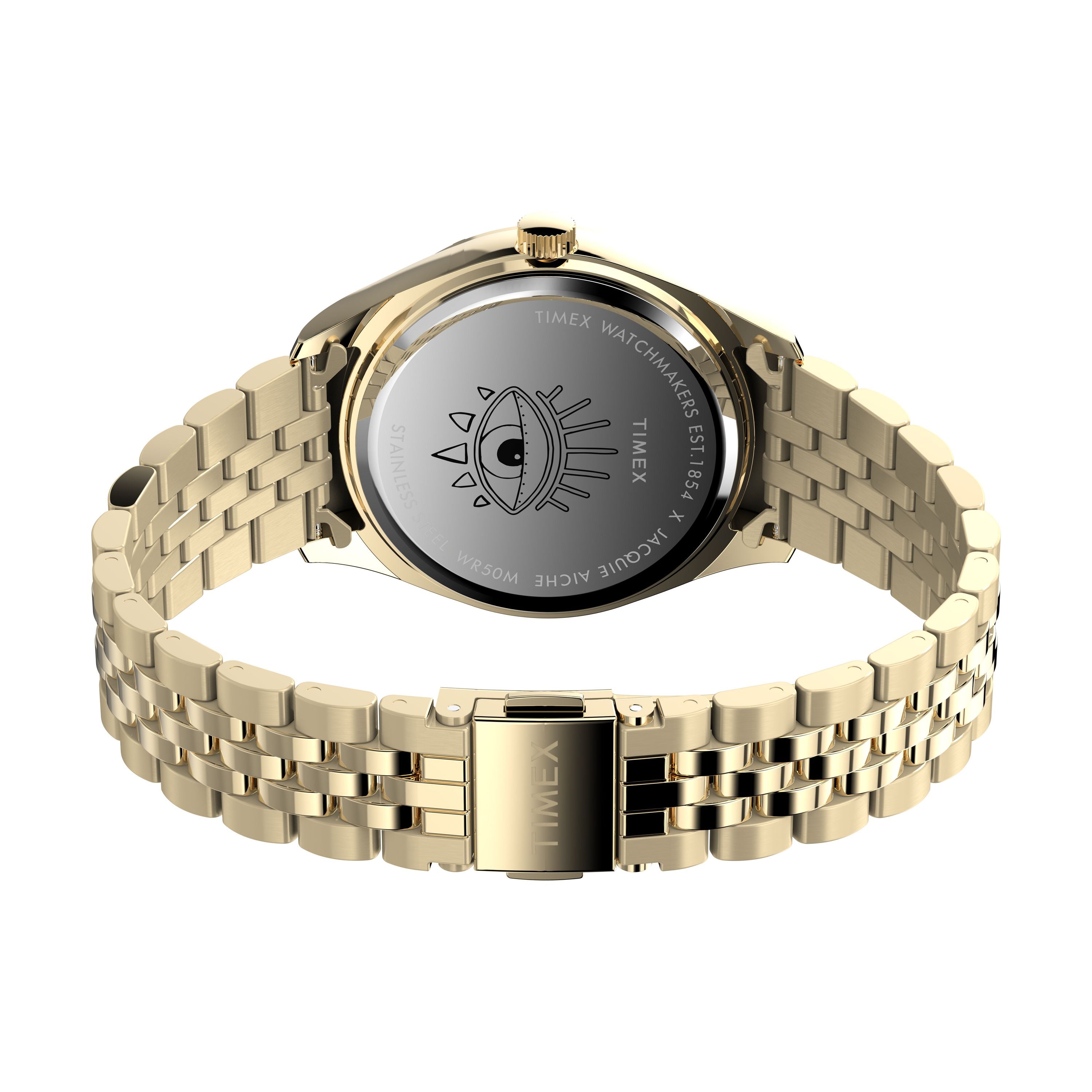 A gold-tone Timex x Jacquie Aiche stainless-steel watch with metal link band, engraved eye and “Timex Watchmakers Est. 1854,” part of the Timex x Jacquie Aiche collection, shown from the back.