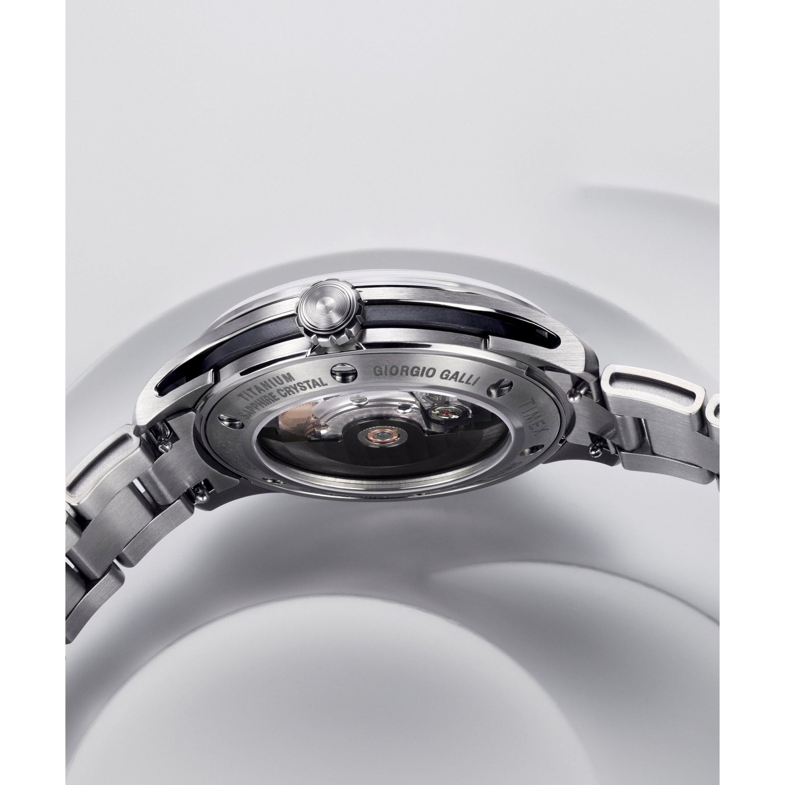 Close-up of the back of the Timex Giorgio Galli S2Ti Automatic, featuring a 38mm titanium case, transparent sapphire crystal back revealing the Swiss automatic movement, engraved details on the case, and a partially visible metal bracelet.