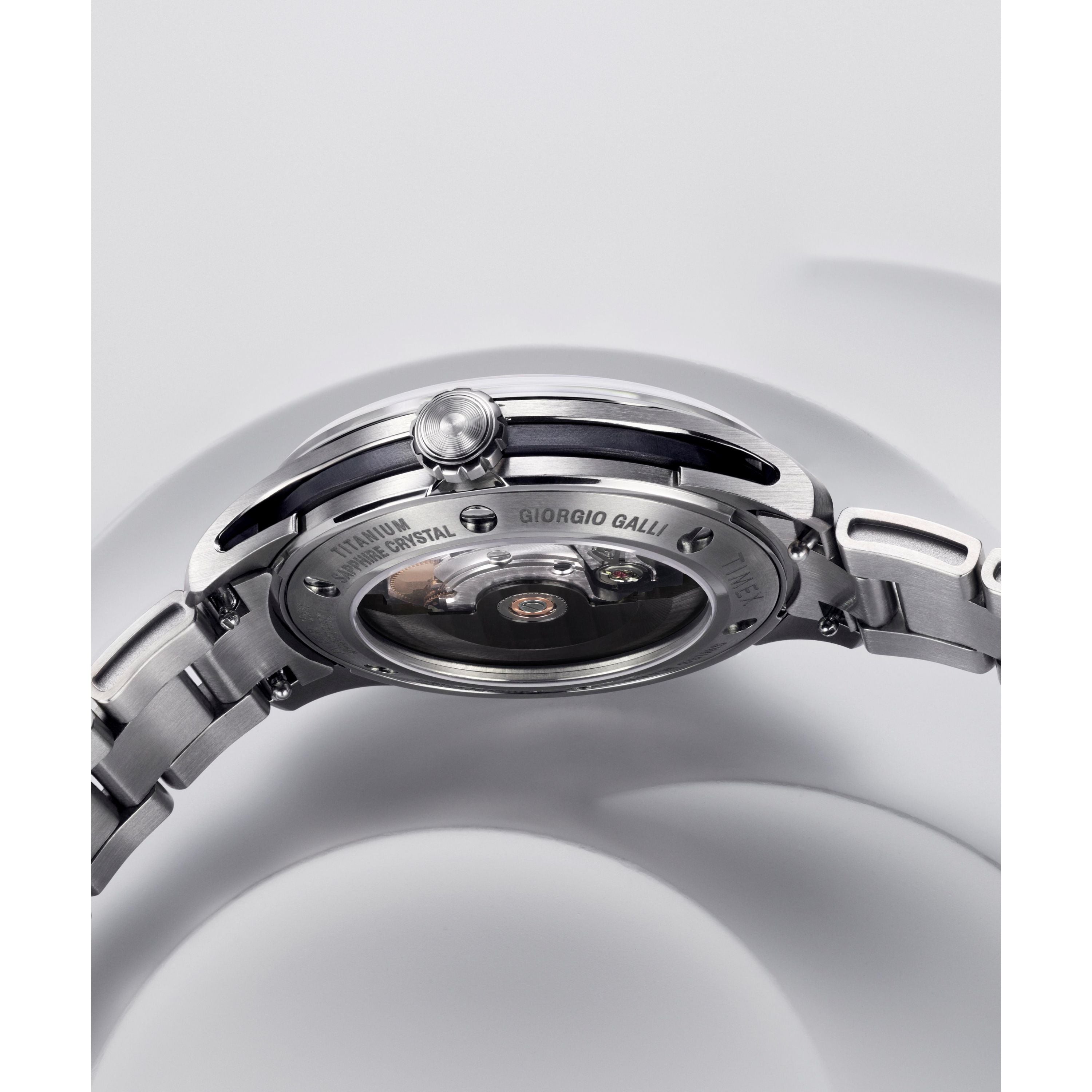 Close-up of the back of the Timex Giorgio Galli S2Ti Automatic, featuring a 38mm titanium case, transparent sapphire crystal back revealing the Swiss automatic movement, engraved details on the case, and a partially visible metal bracelet.
