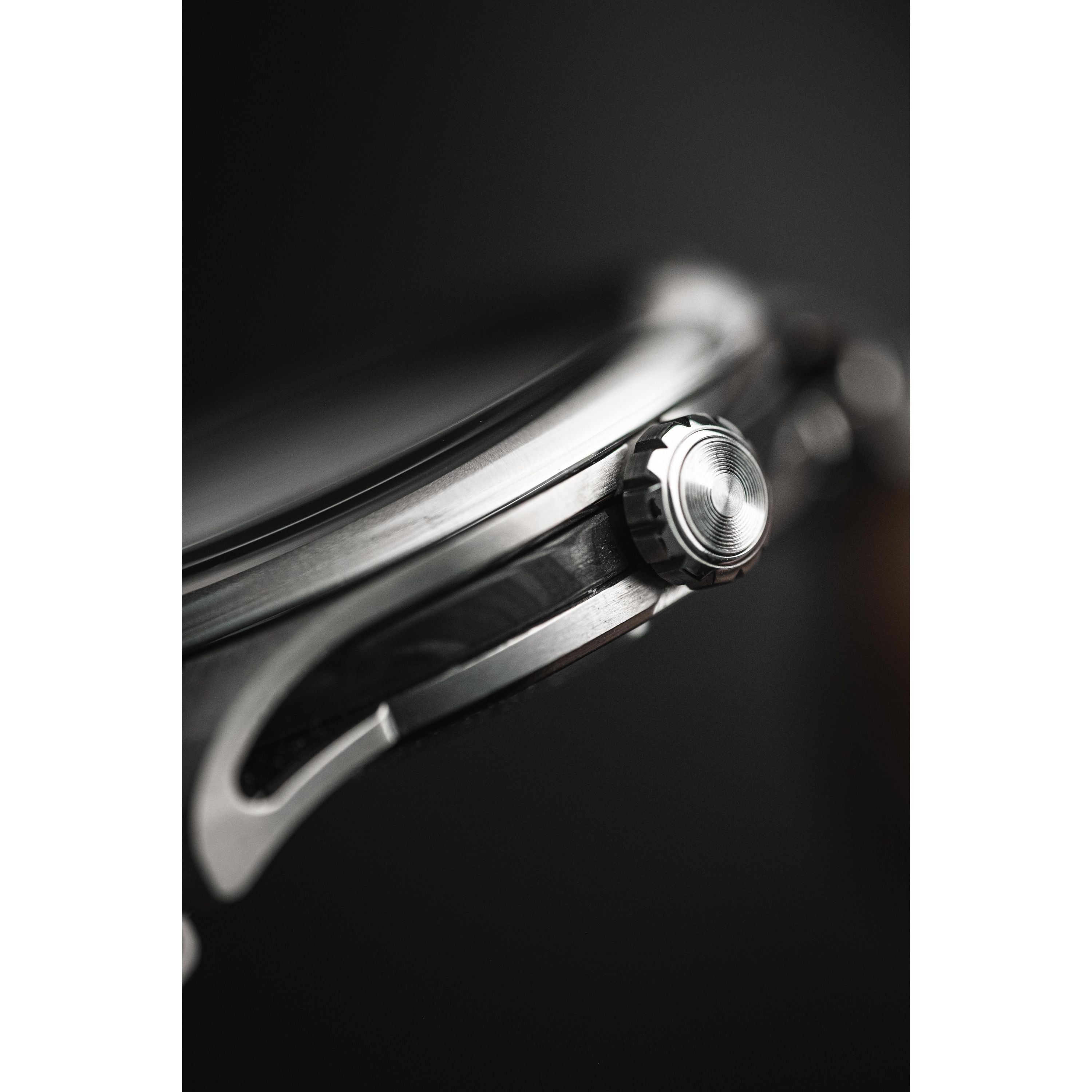 Close-up side view of the 38mm titanium case and crown of the Timex Giorgio Galli S2Ti Automatic, showcasing its detailed metal texture and craftsmanship against a dark, blurred background.