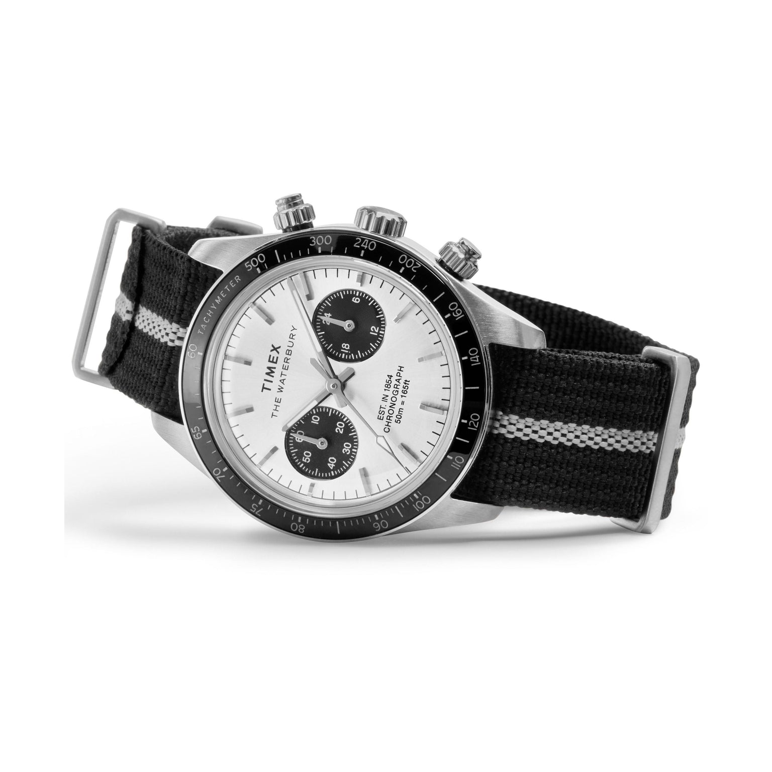 The Timex Waterbury Heritage Chronograph features a black and white face, two subdials, a silver bezel, three side buttons, and a black recycled fabric strap with a white center stripe.