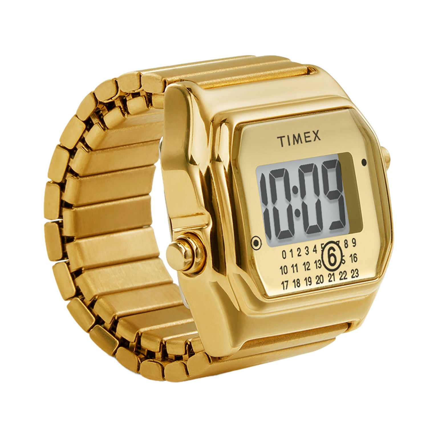 The Timex MM6 Gold Tone Digital Ring Watch features a gold-tone design and displays 10:09 on its rectangular screen with black numerals and a row of small buttons beneath.