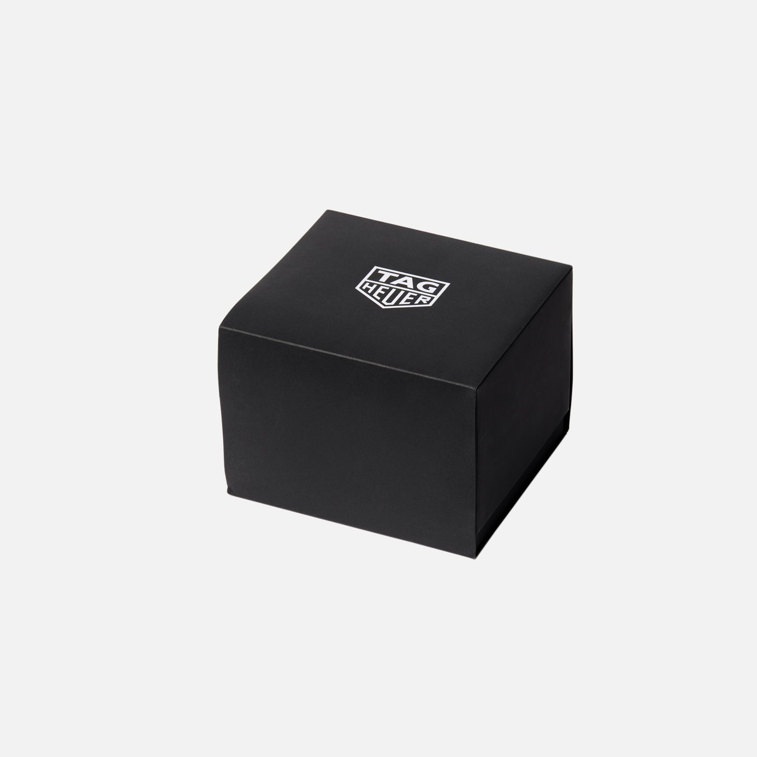 A black TAG Heuer box featuring the brand’s logo on top, pictured against a plain white background, holds the TAG Heuer Carrera Chronograph Seafarer × Hodinkee.