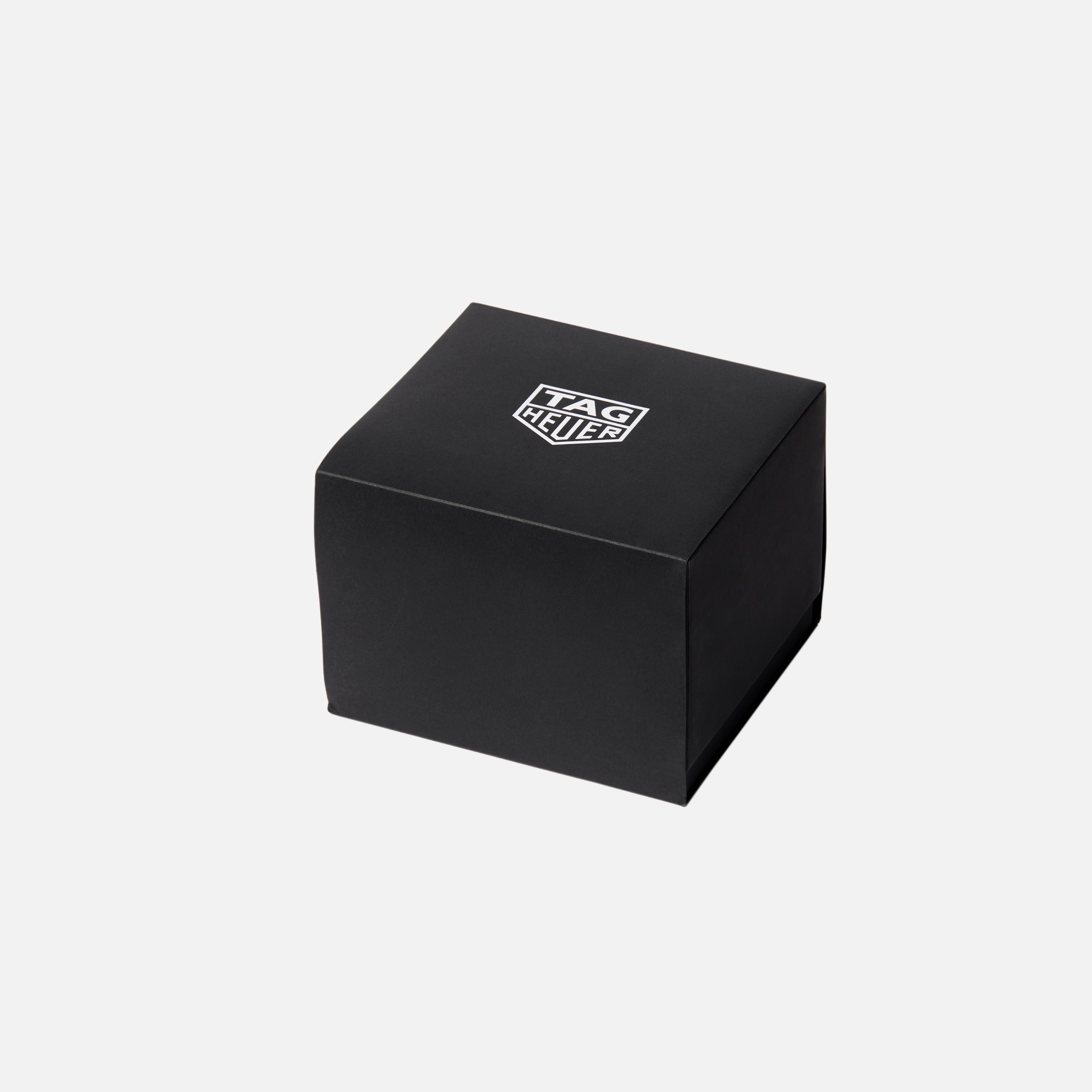 A black TAG Heuer box featuring the brand’s logo on top, pictured against a plain white background, holds the TAG Heuer Carrera Chronograph Seafarer × Hodinkee.