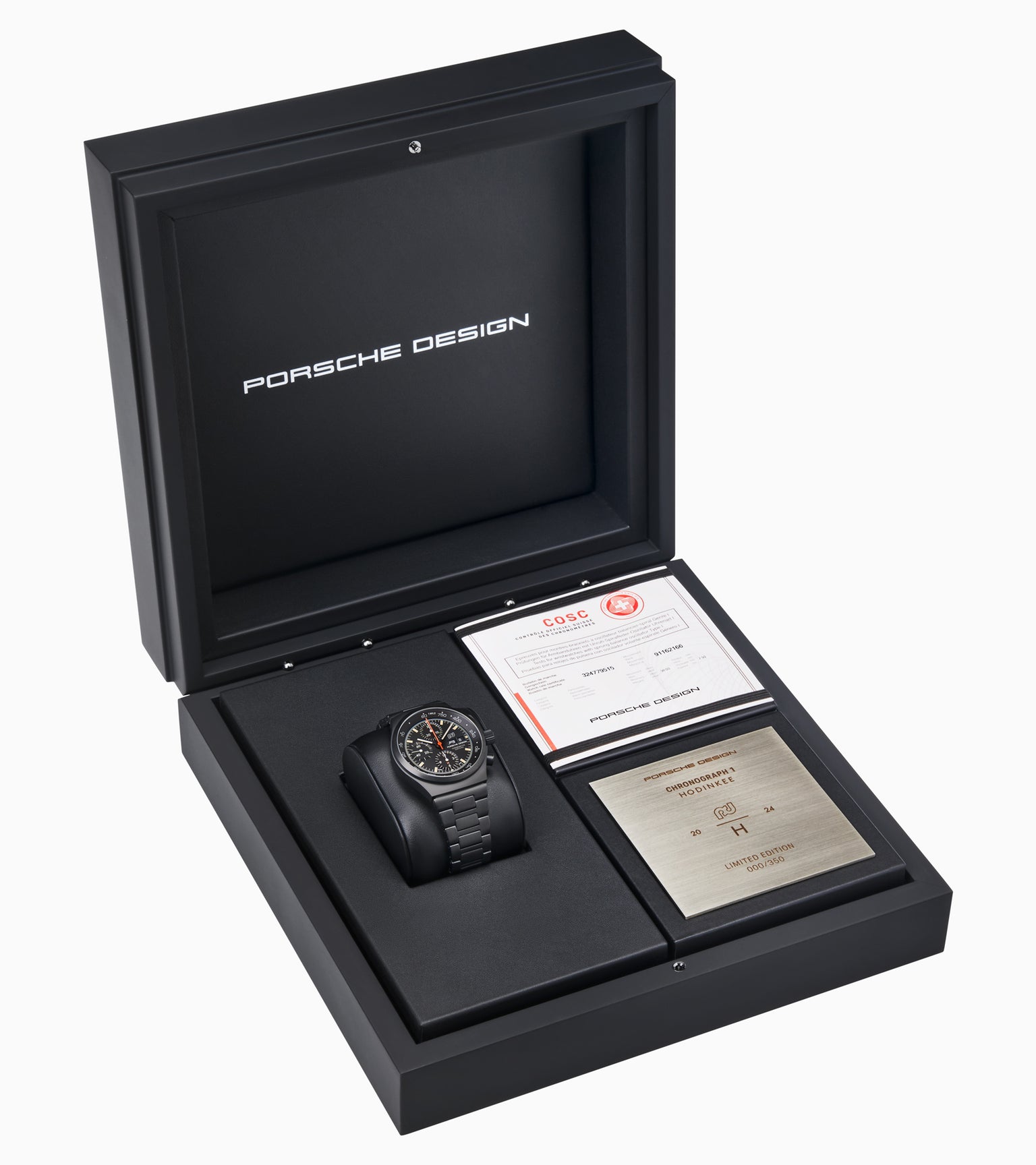 The Porsche Design Chronograph 1 Hodinkee 2024 Edition watch is presented in a black box with certificates and a plaque beside it.