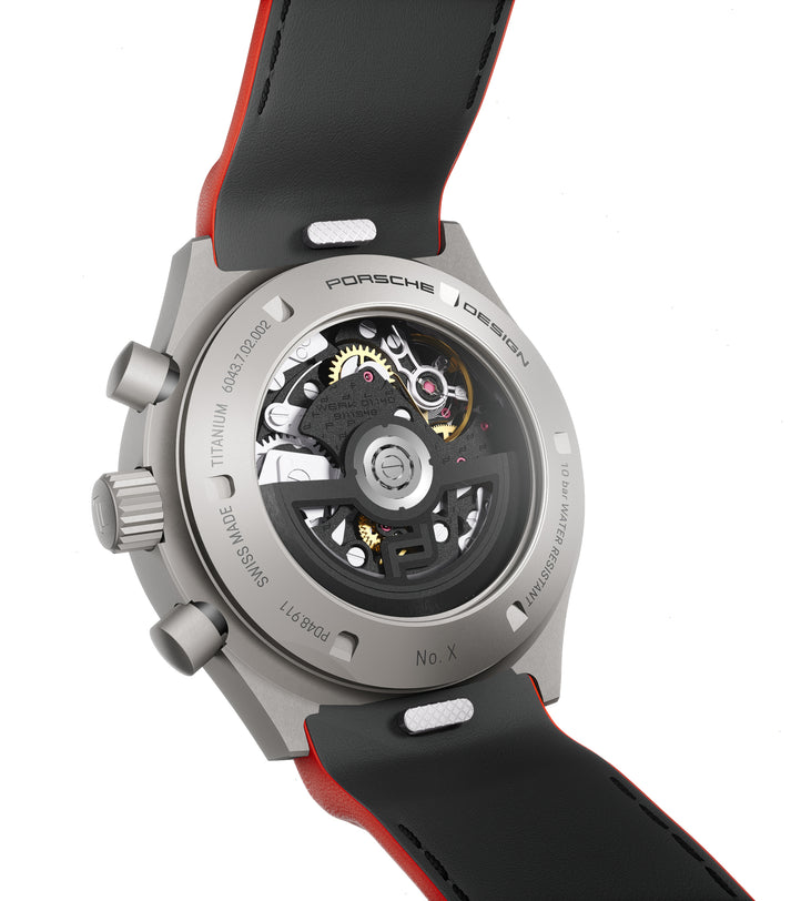 Titanium chronograph watch with exposed mechanical movement, black and red leather strap, numbered edition detail visible on 