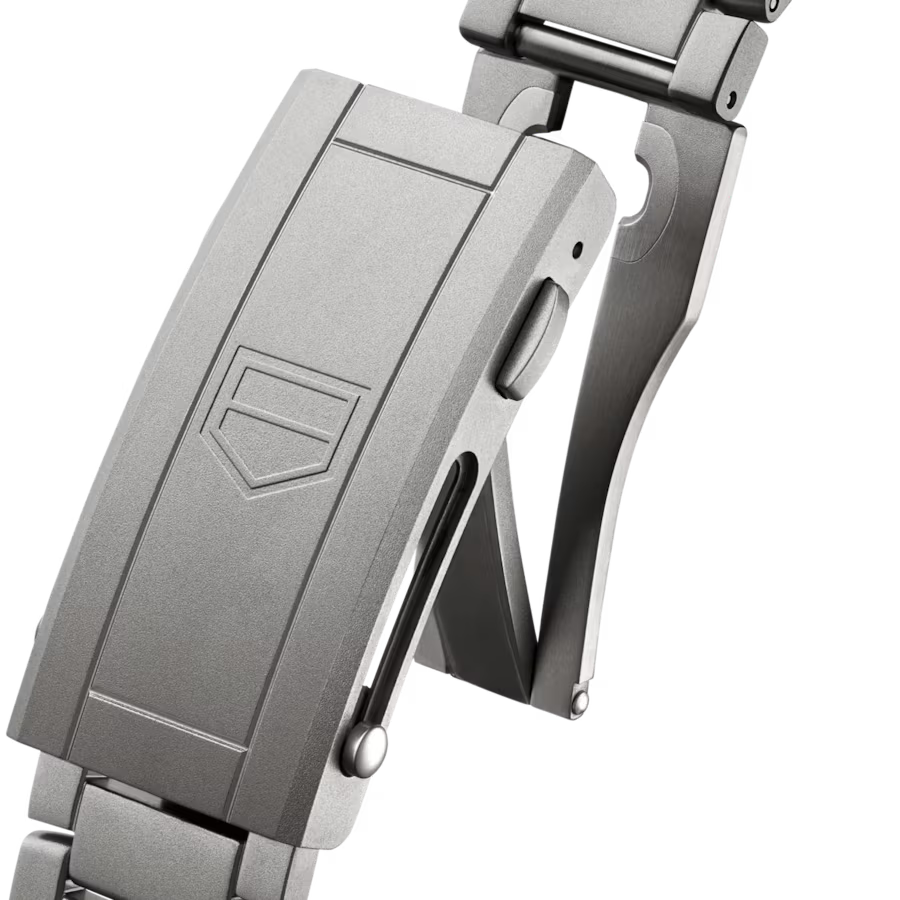 Stainless steel watch bracelet and clasp with shield emblem detail shown from side angle.
