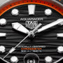 TAG Heuer Aquaracer Professional 500 watch face with orange bezel, black dial, white hour markers, and white hands.