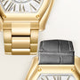 Gold-tone watch with cushion dial, matching bracelet, and black leather strap shown from above.
