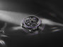 Luxury watch with intricate design on a dark fabric background