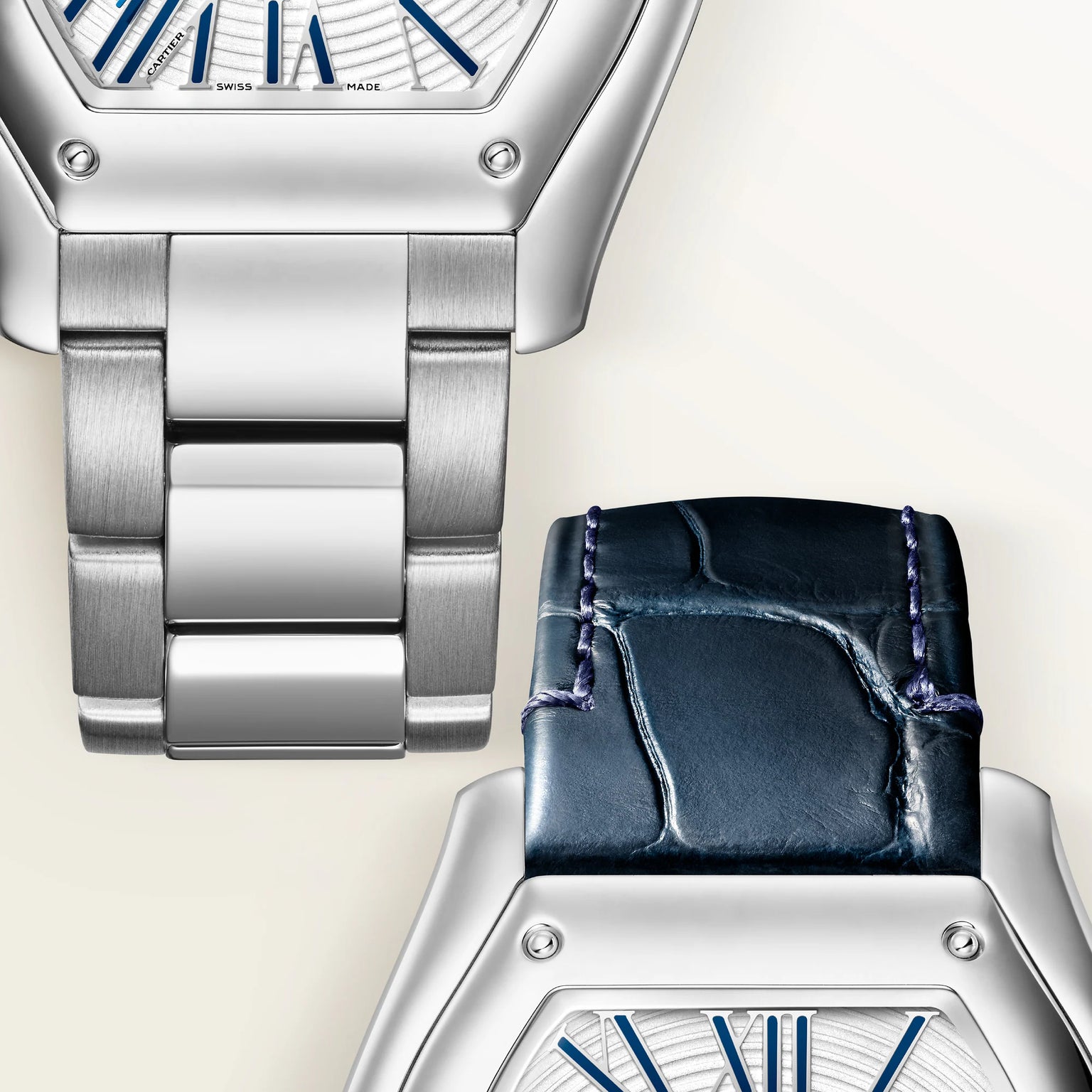 Two watches with silver tonneau cases and blue dial details, one with metal bracelet and one with dark blue leather strap.