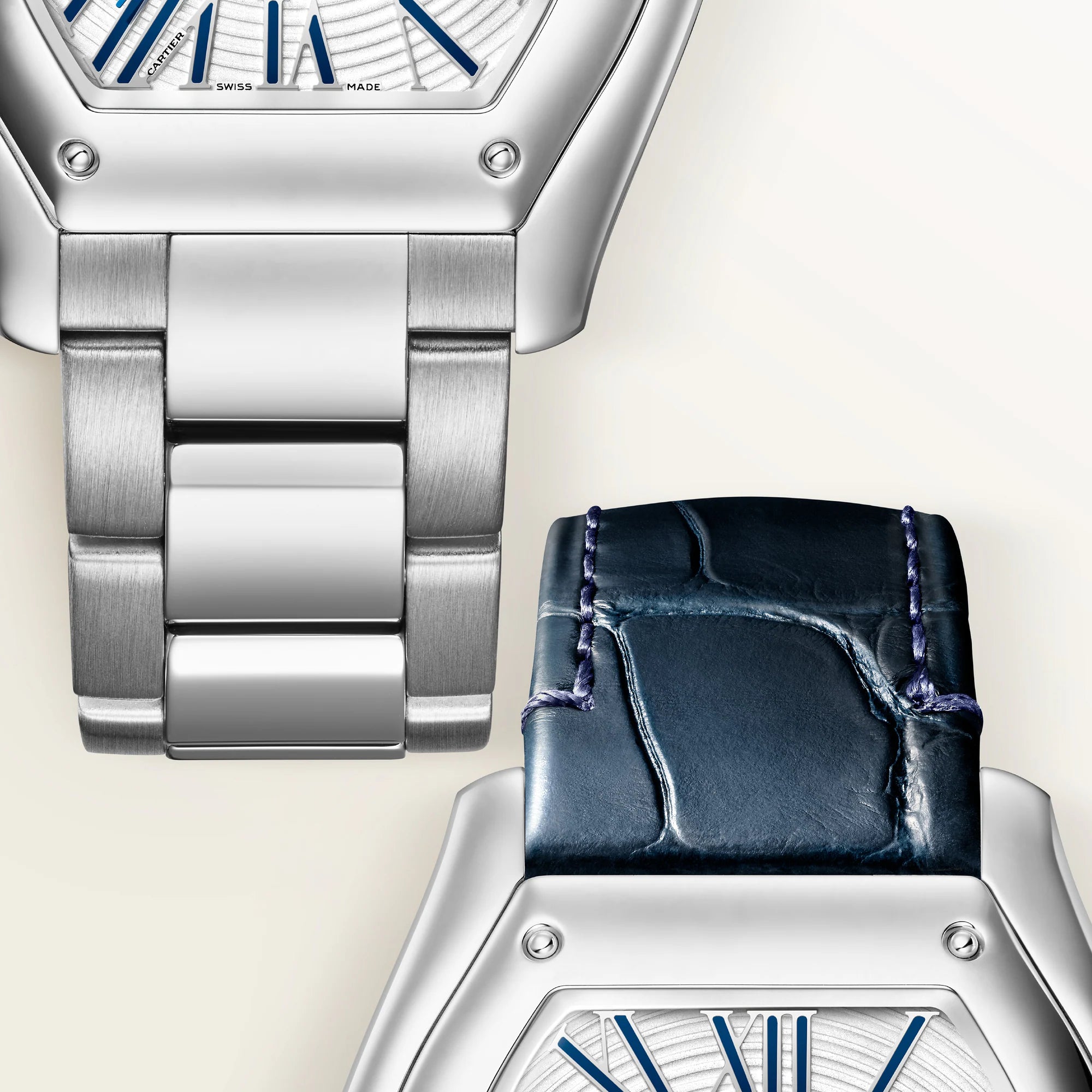 Two watches with silver tonneau cases and blue dial details, one with metal bracelet and one with dark blue leather strap.