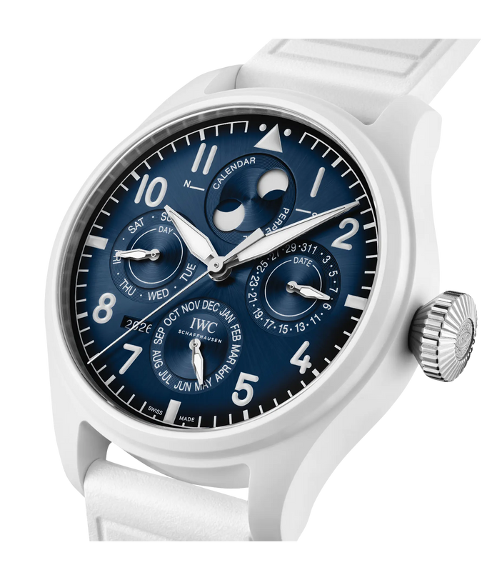 White pilot watch with dark blue dial featuring perpetual calendar, moon phase, and multiple subdials on rubber strap.
