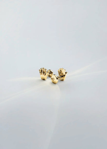Gold stud earrings on a light gray background