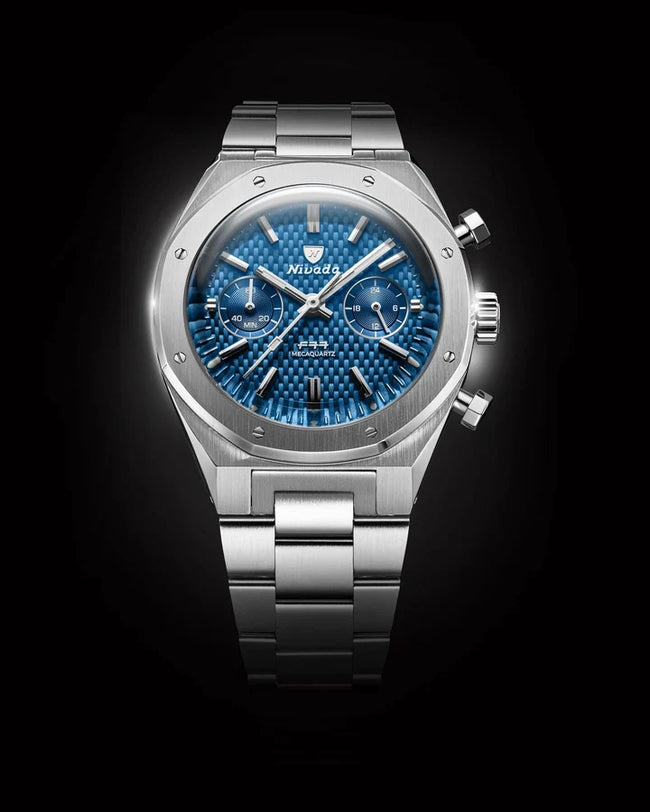 Stainless steel chronograph watch with blue dial, dual subdials, and matching metal bracelet.
