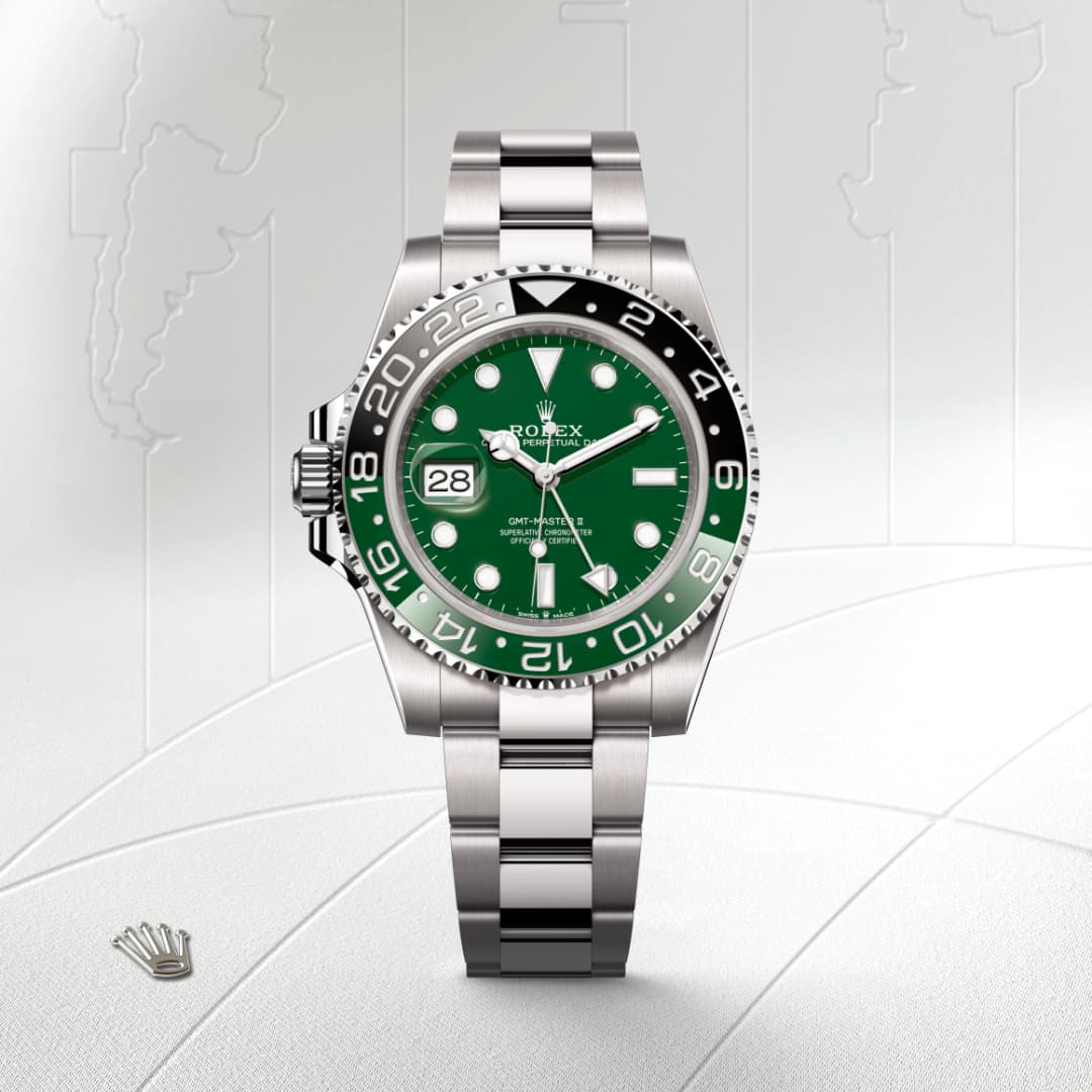 A silver Rolex watch with a green dial and black bezel, displayed against a light map-patterned background.