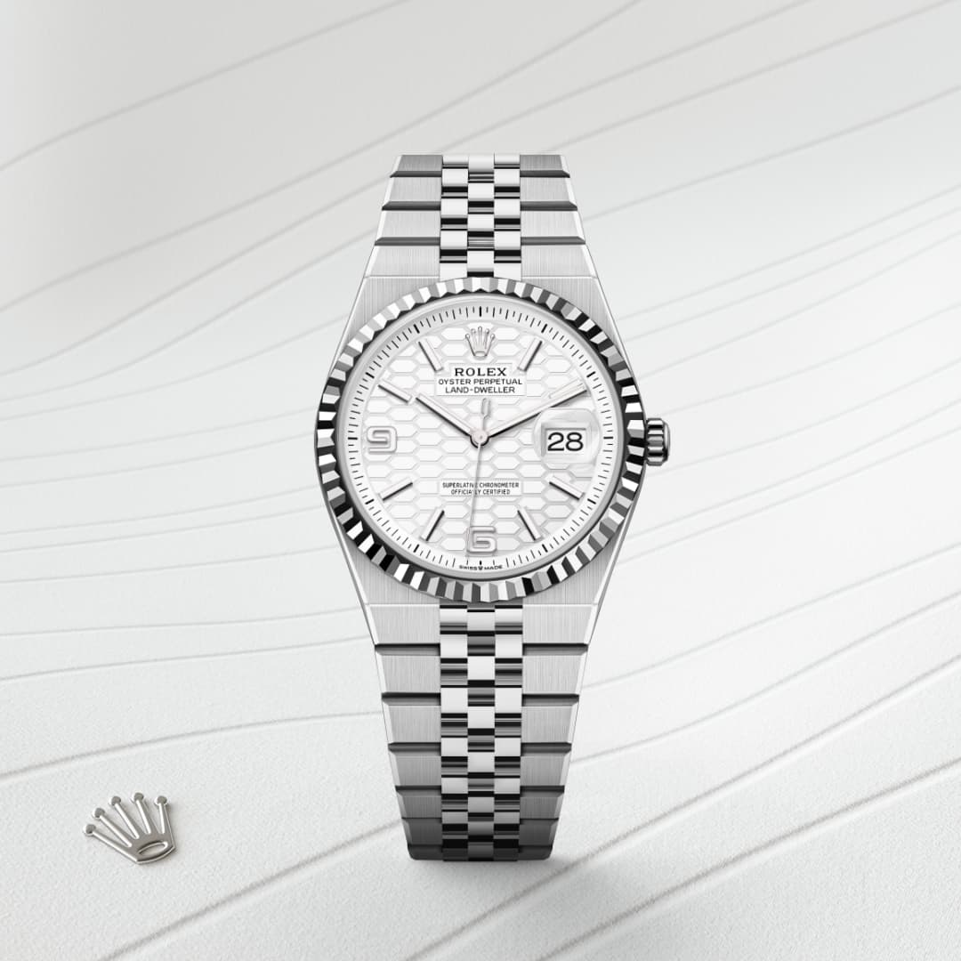 A silver Rolex watch with a white patterned dial and date display, on a light textured background.
