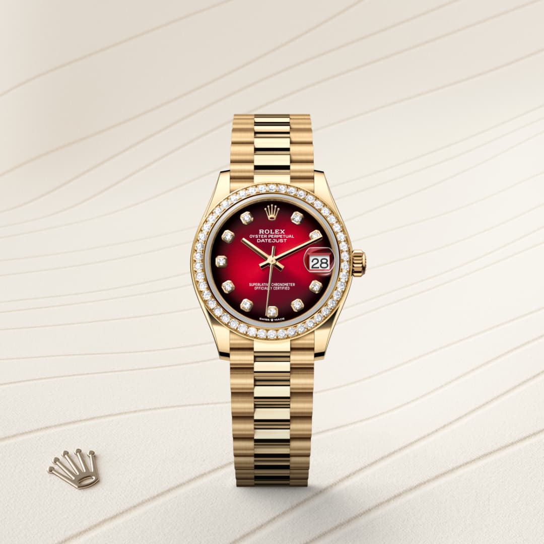 A gold Rolex watch with a red dial, diamond bezel, and date display, set on a beige textured background.