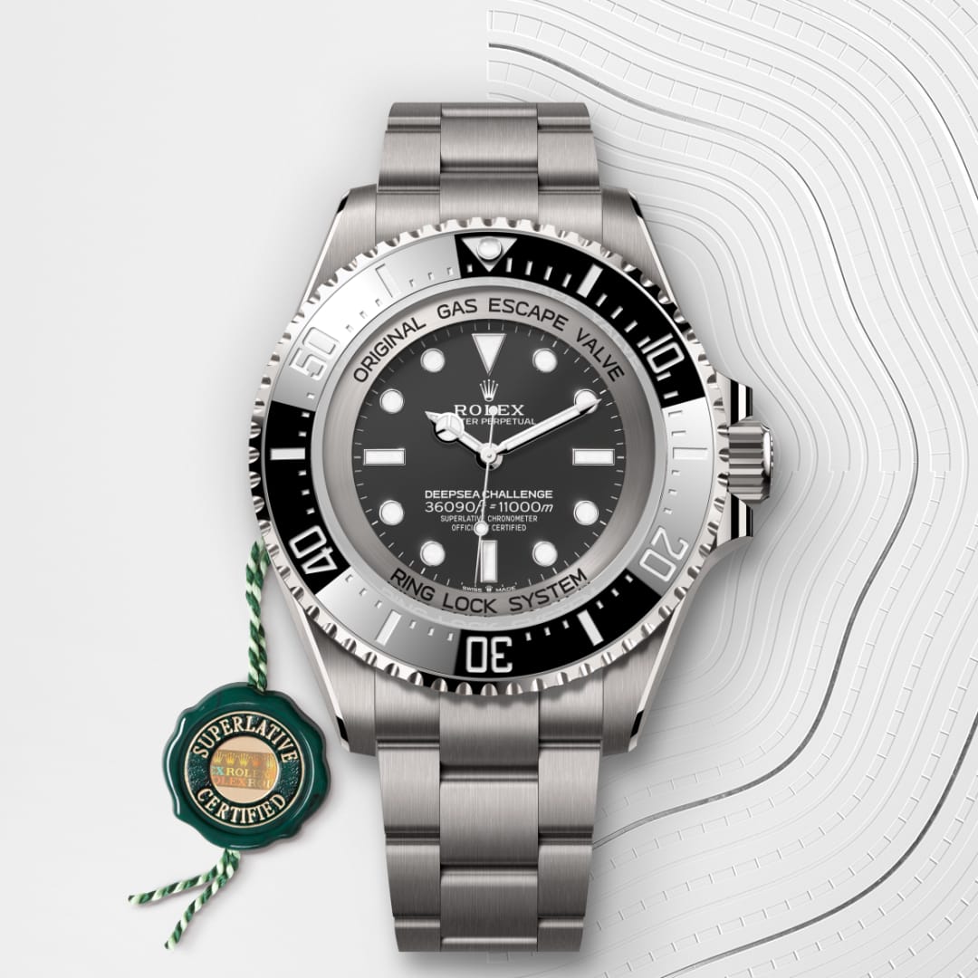 A Rolex Deepsea Challenge watch with a stainless steel band and certification tag on a patterned white background.