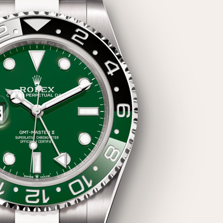 Close-up of a Rolex GMT-Master II watch with a green dial and black-and-silver bezel.