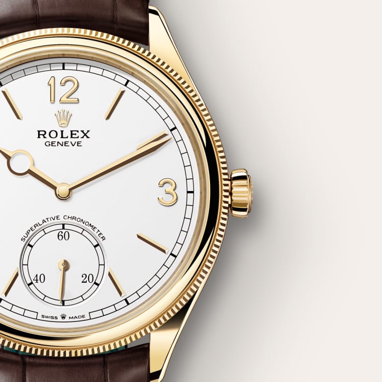 Close-up of a gold Rolex wristwatch with a white dial and brown leather strap, showing time at 10:10.
