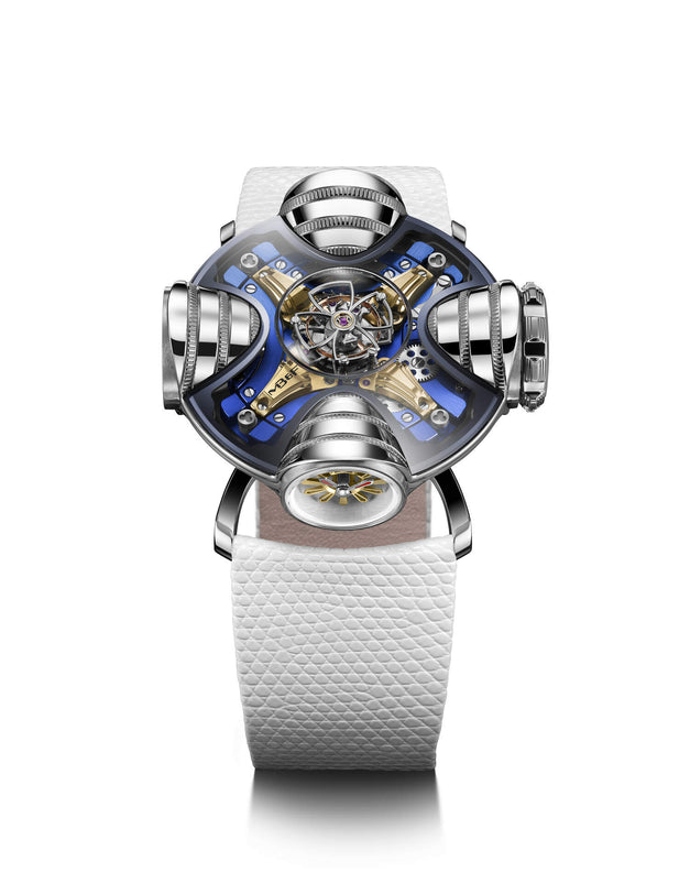 The MB&F HM11 Art Deco watch features a complex mechanical design, blue and gold metal accents, a skeletonised dial, and a white textured leather strap, all showcased against a white background.