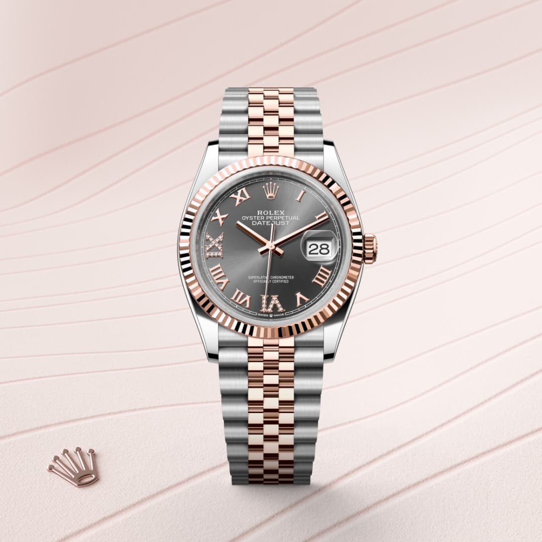 A two-tone Rolex watch with a silver and rose gold bracelet, gray dial, and Roman numerals on a textured background.