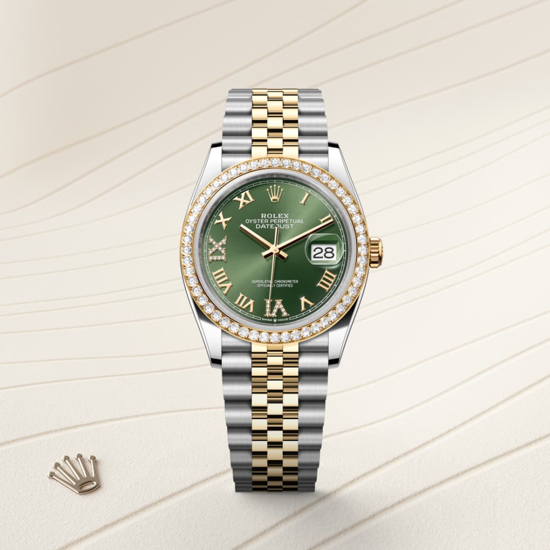 A gold and silver Rolex watch with a green face, Roman numerals, and diamond bezel on a textured background.