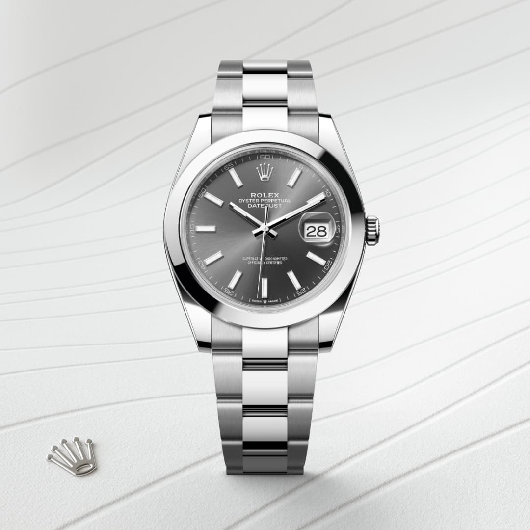A silver Rolex watch with a gray dial and date display on a textured white background.