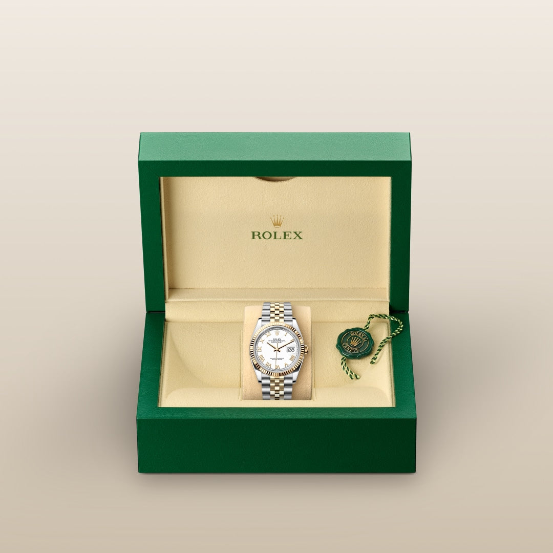 A luxury Rolex watch in a green and beige box, with a green tag inside the box.