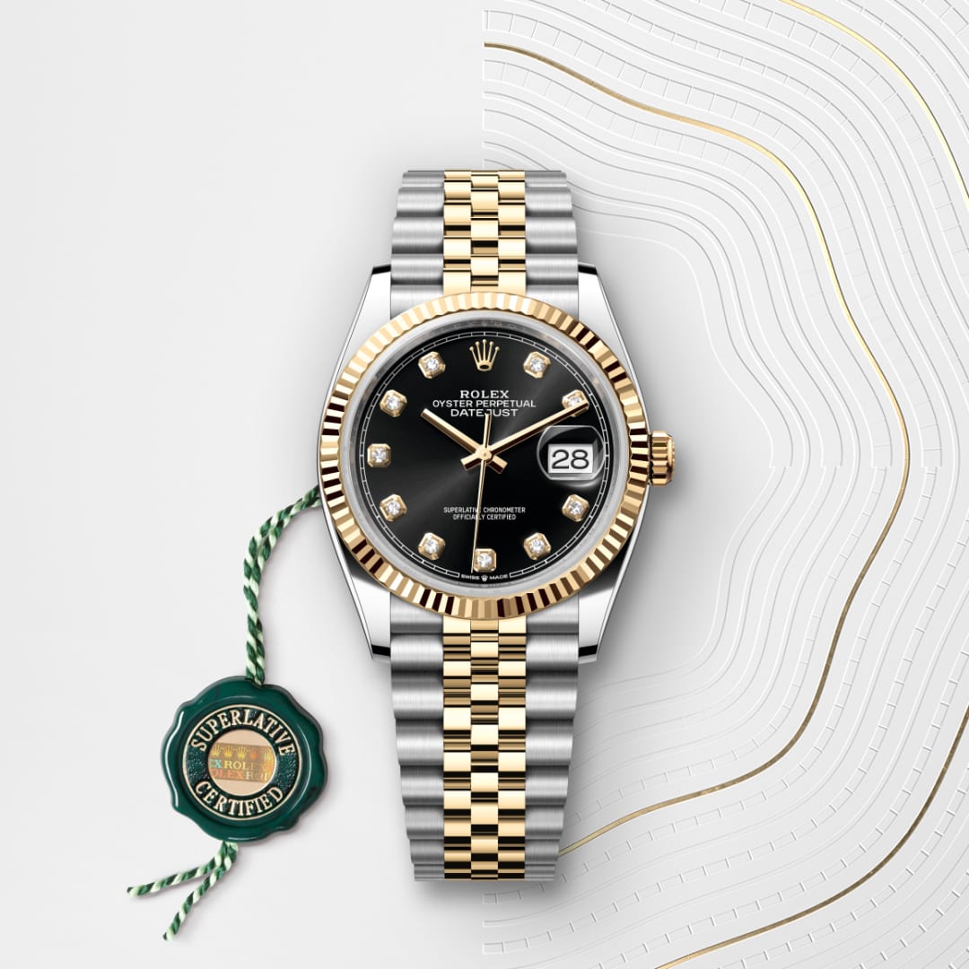 A Rolex two-tone watch with a black dial, diamond markers, and a Superlative Certified green tag.