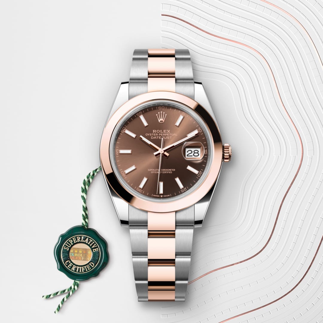 A Rolex Datejust watch with a rose gold and silver band, next to a green Superlative Certified tag.