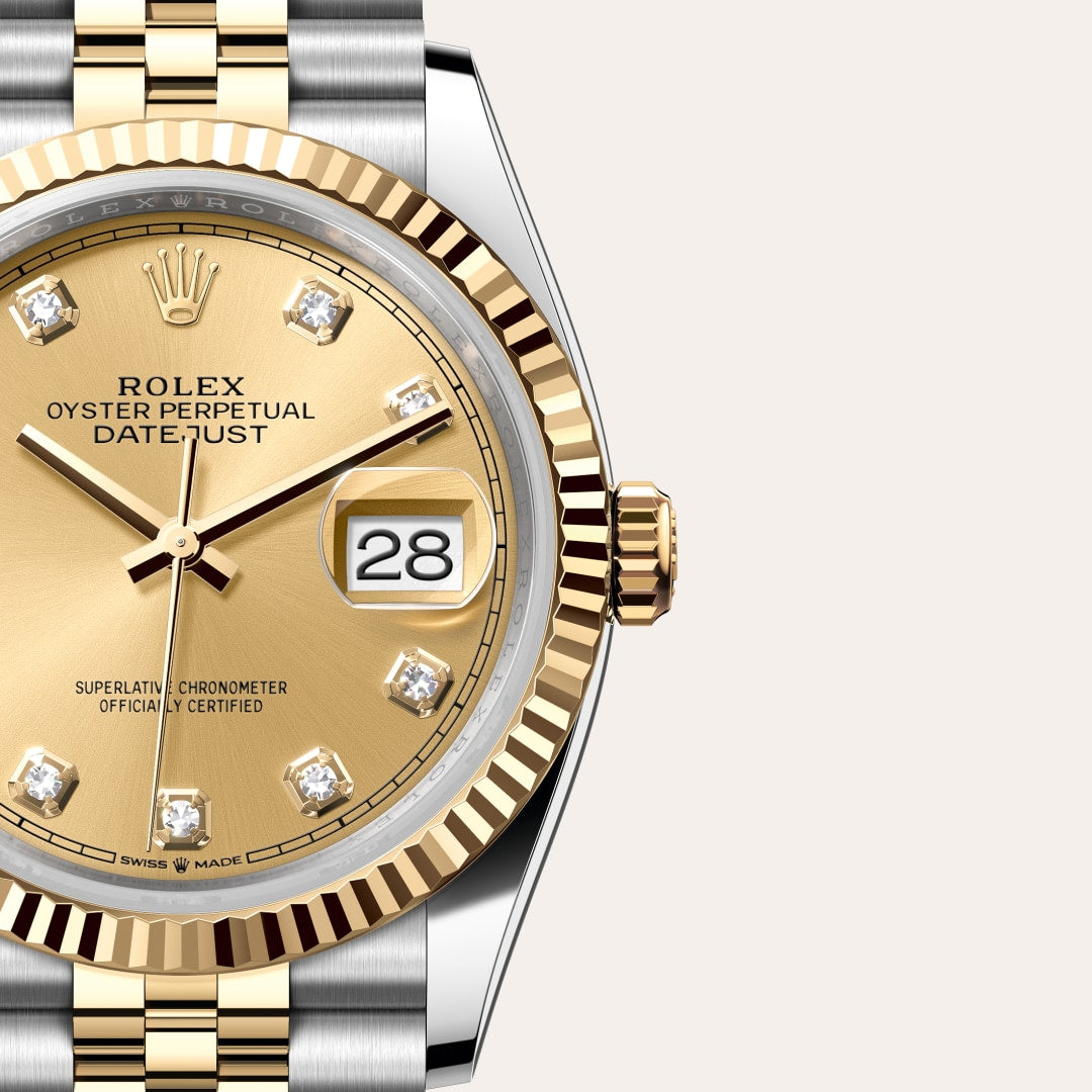 Close-up of a gold and silver Rolex Datejust watch with diamond hour markers and the date set to 28.