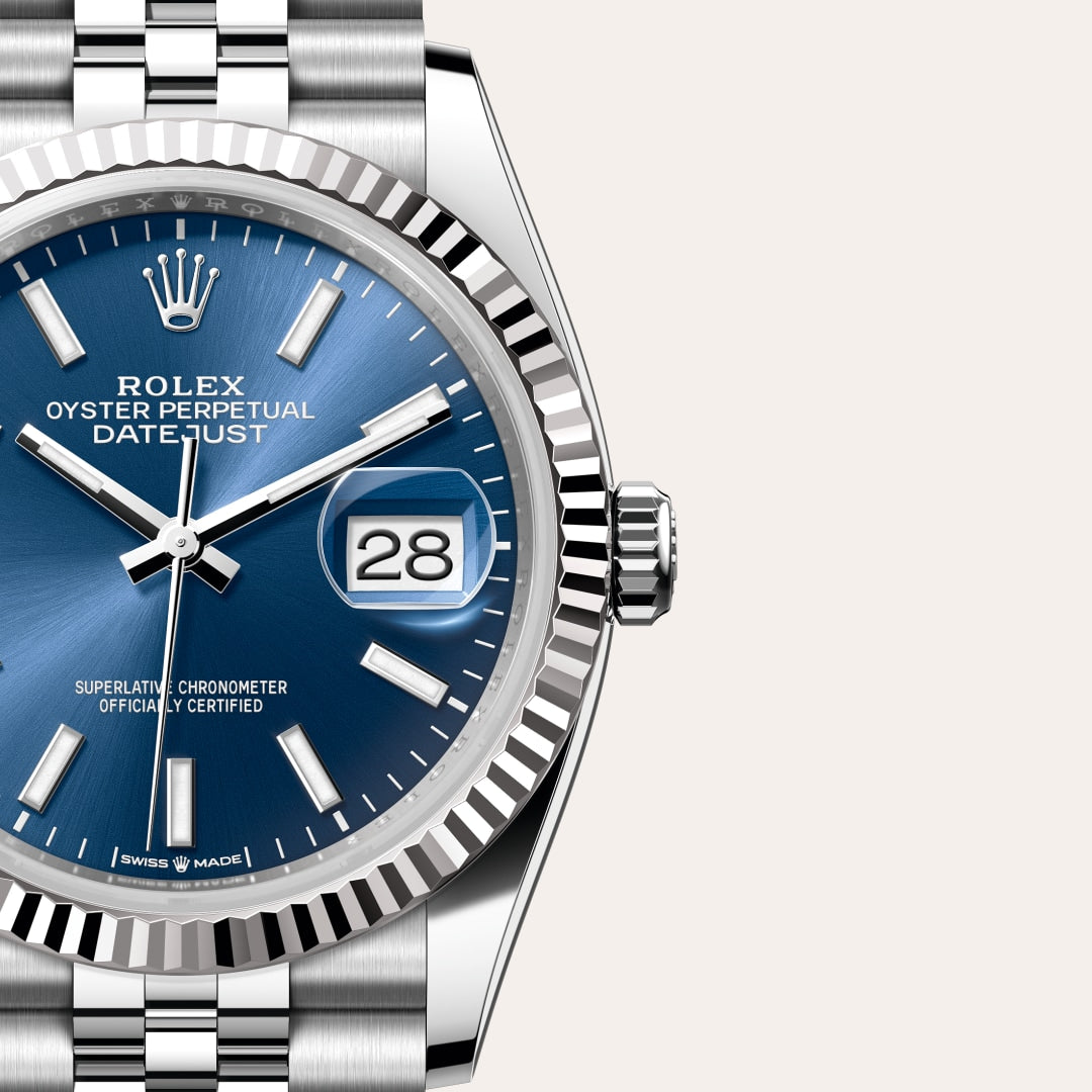 Close-up of a Rolex Datejust watch with a blue dial, silver markers, and date window showing the number 28.