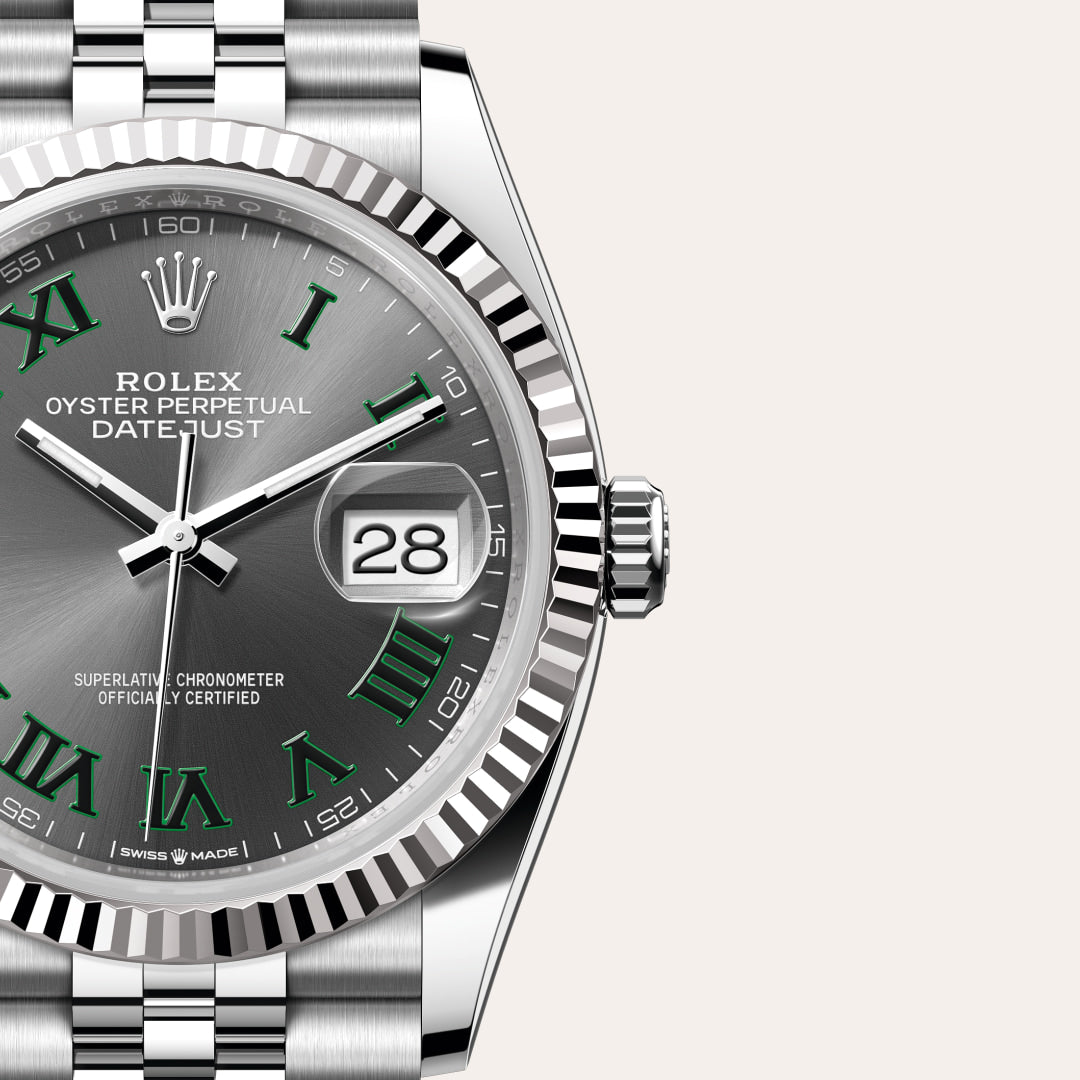 Close-up of a Rolex Datejust watch with a silver dial, green Roman numerals, and a date display at 3 oclock.