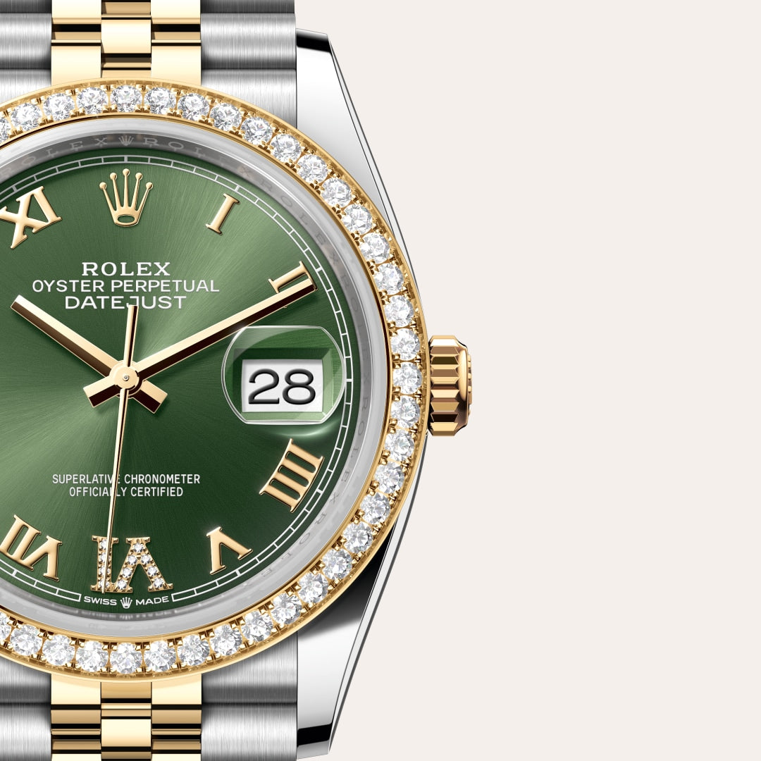Close-up of a Rolex Datejust watch with a green dial, Roman numerals, diamond bezel, and gold accents.