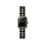 The Première Édition Originale Small Model by Chanel is a luxury wristwatch with a rectangular black-lacquered dial, yellow gold steel case, chain-link bracelet woven with black leather, gold hands, and "CHANEL" on the dial.