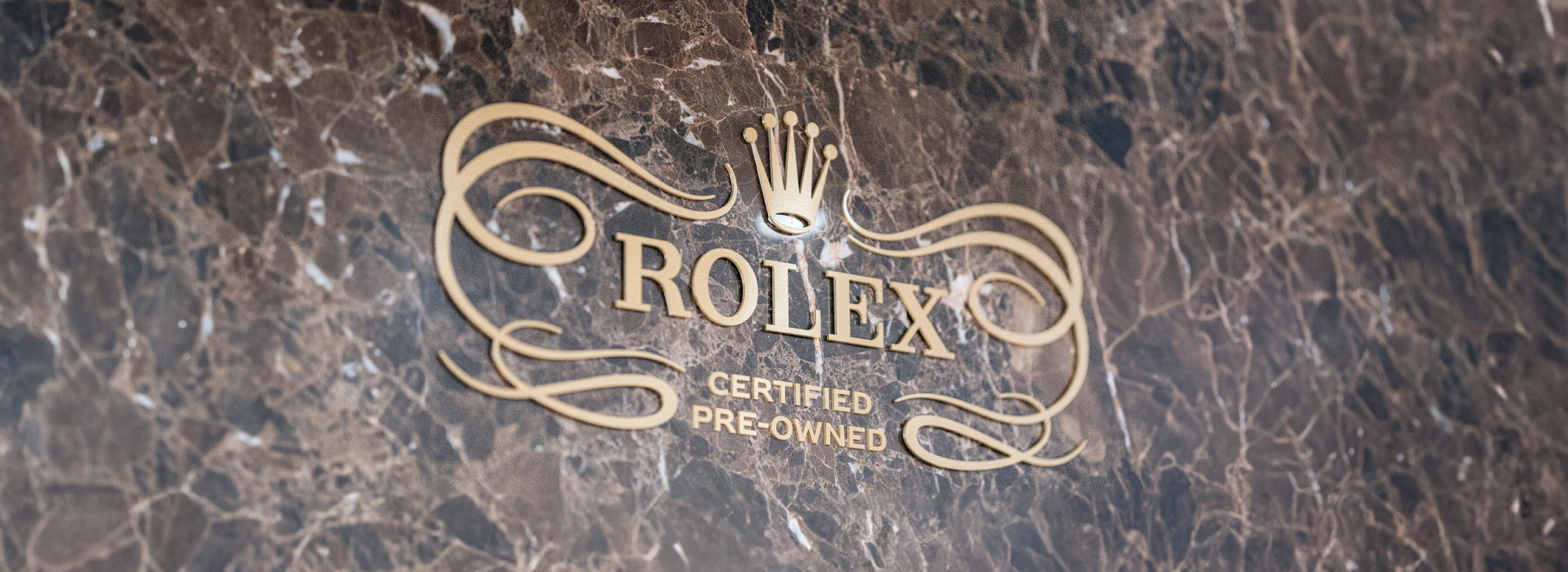 Gold Rolex Certified Pre-Owned logo on a dark marble background.